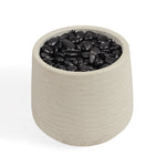 A cylindrical fibreclay pot filled with smooth black decorative stones, shown on a clean white background.