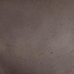 A close-up texture shot of a dark brown, matte, and slightly granular material surface.