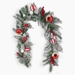 A festive Christmas wreath decorated with frosted green pine branches, red berries, red-and-white striped ornaments, white baubles, and donut ornaments, shown on a plain white background.