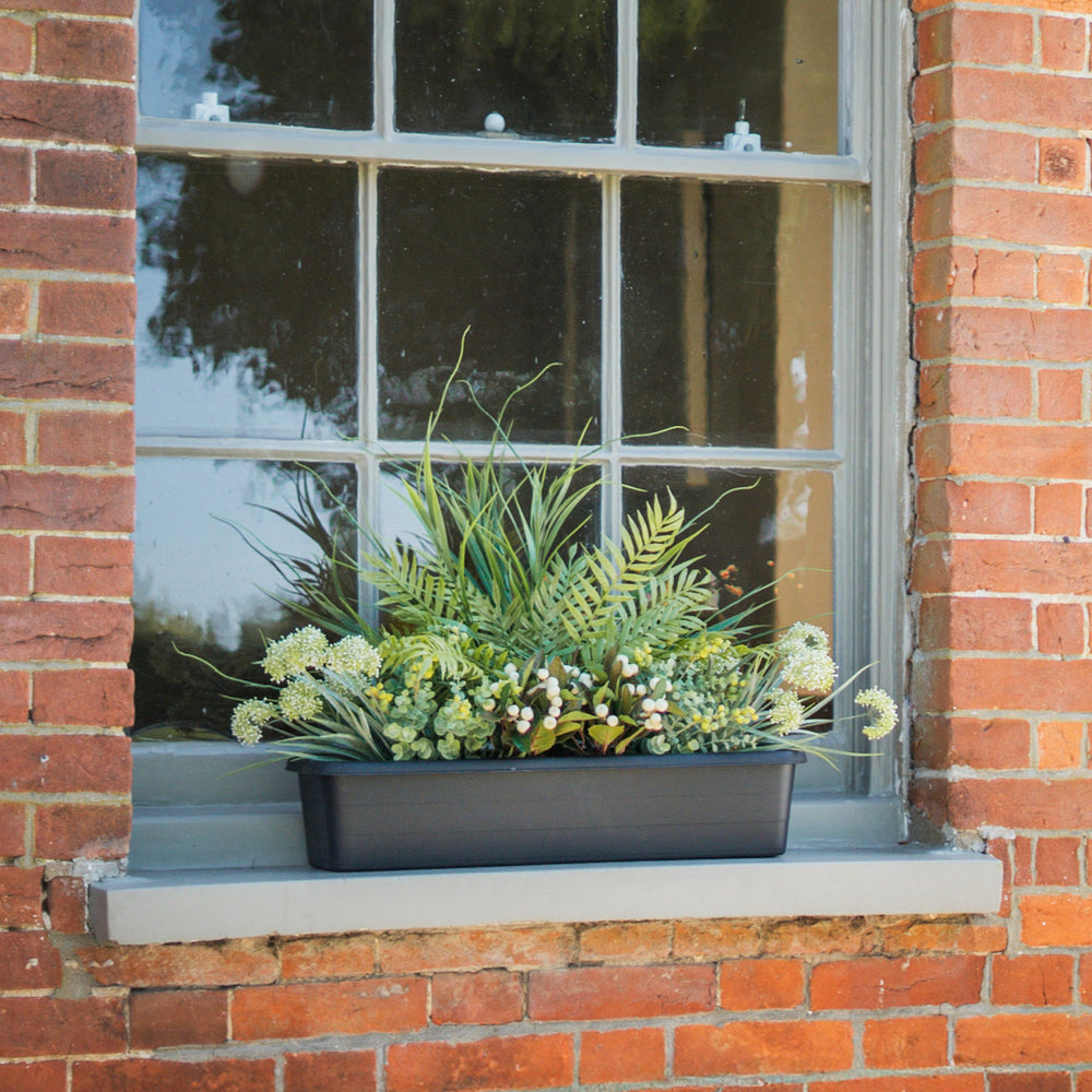 Window box with greenery on a brick window sill