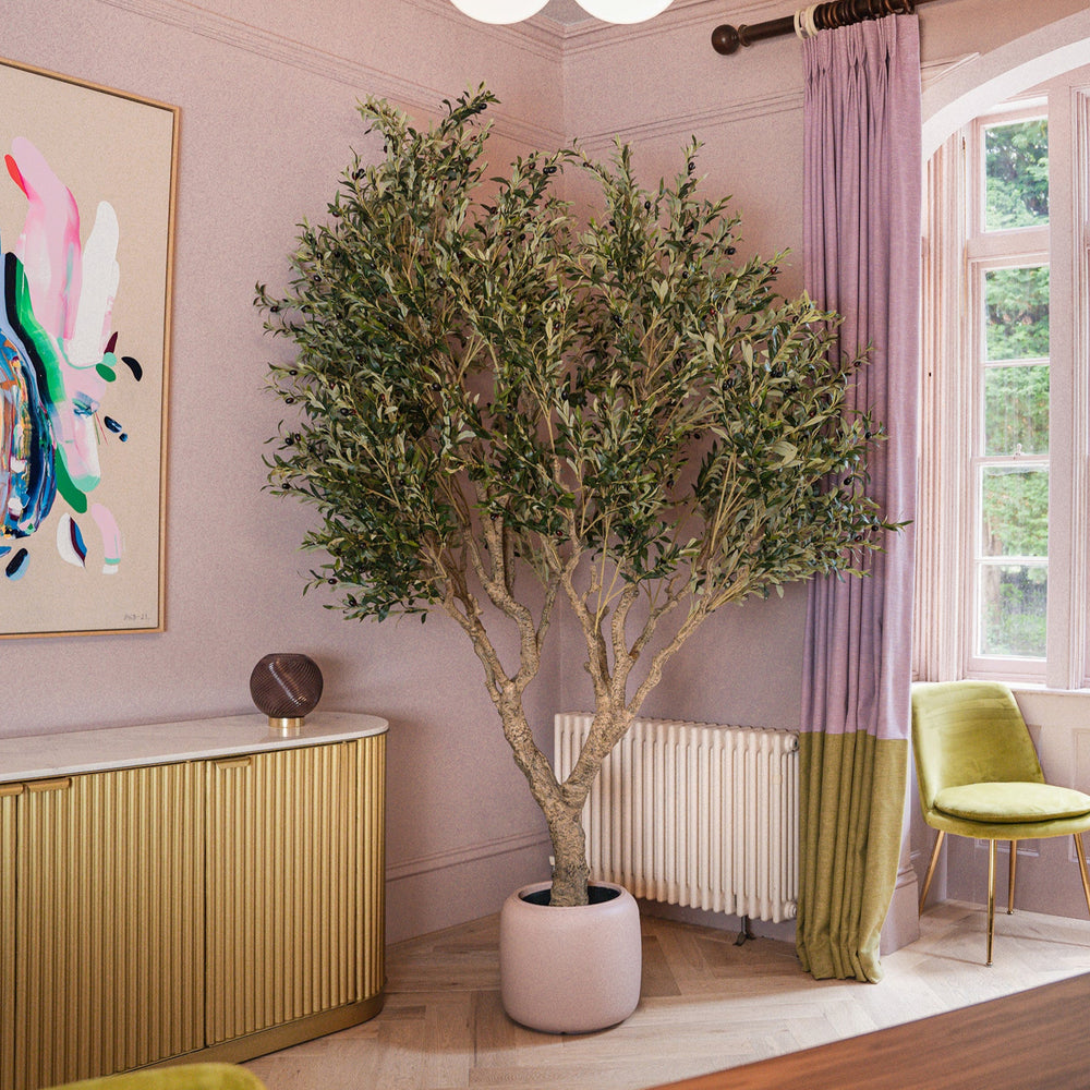 Modern interior with a potted plant, colorful abstract art, and a yellow chair.