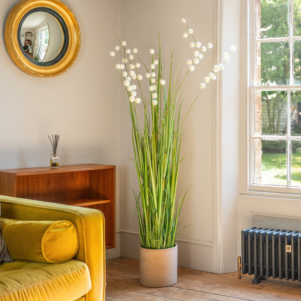Living room with yellow sofa, plant, and window view