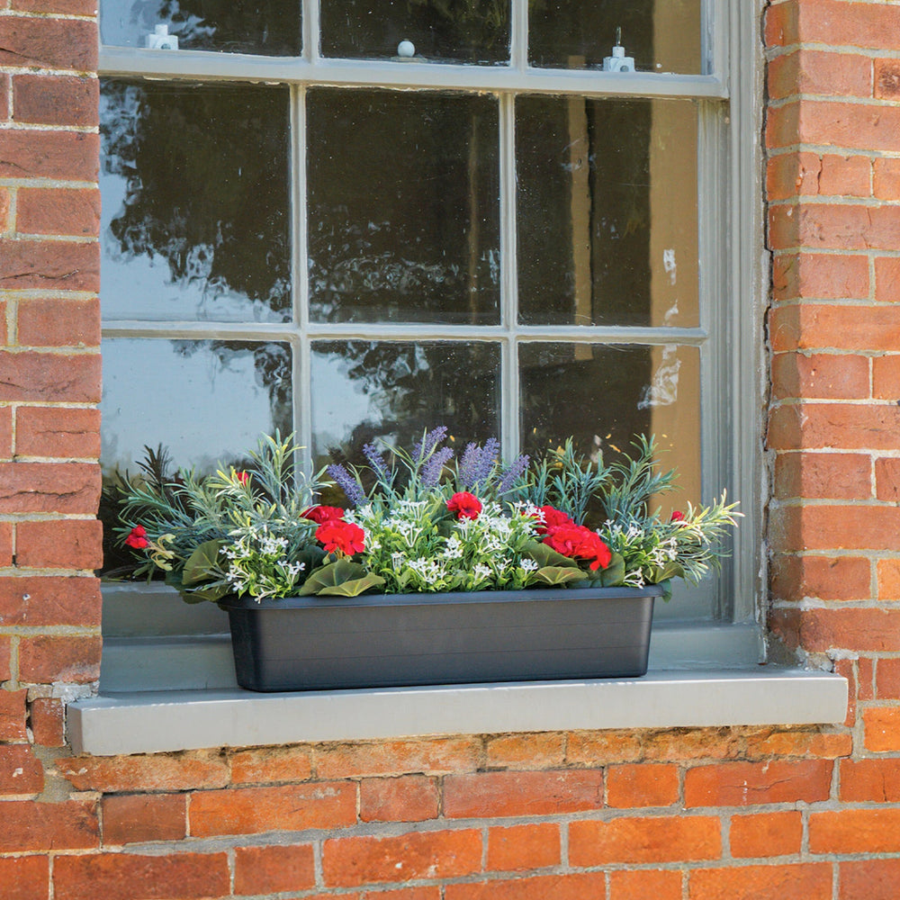 Window box with flowers on a brick window sill
