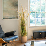Modern living room with a black leather chair, plant, and radiator.