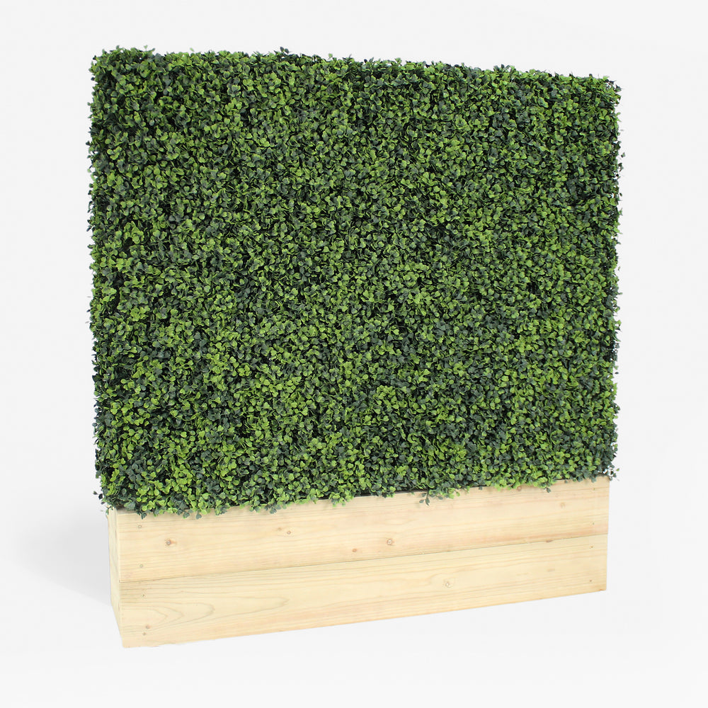 Artificial hedge with wooden base on a white background