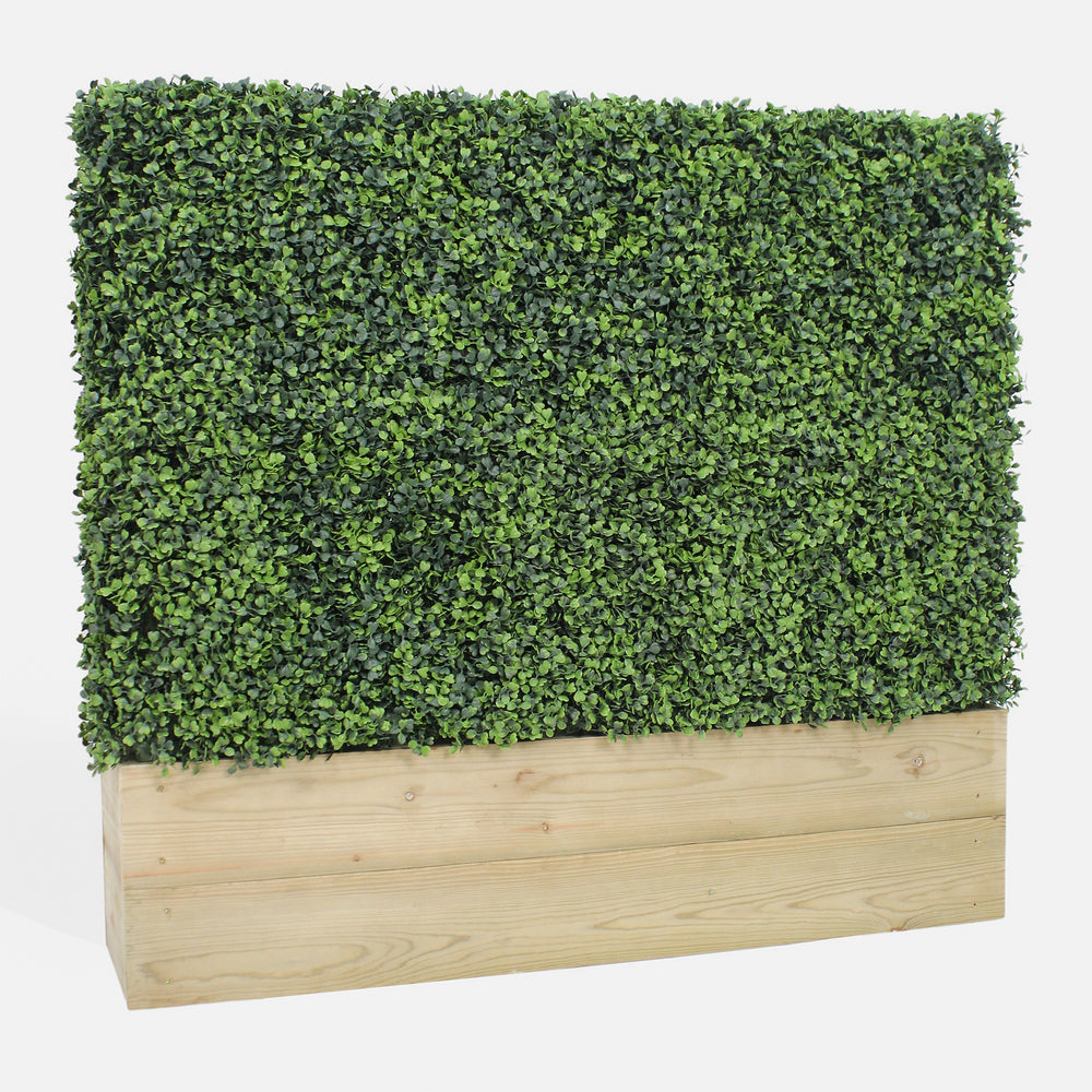 Artificial hedge in a wooden planter on a white background