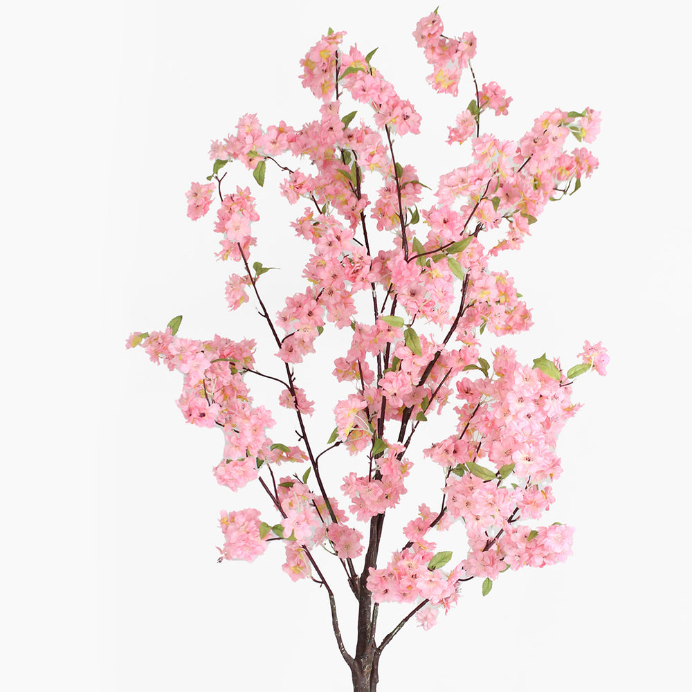 Artificial cherry blossom branch with pink flowers on a white background