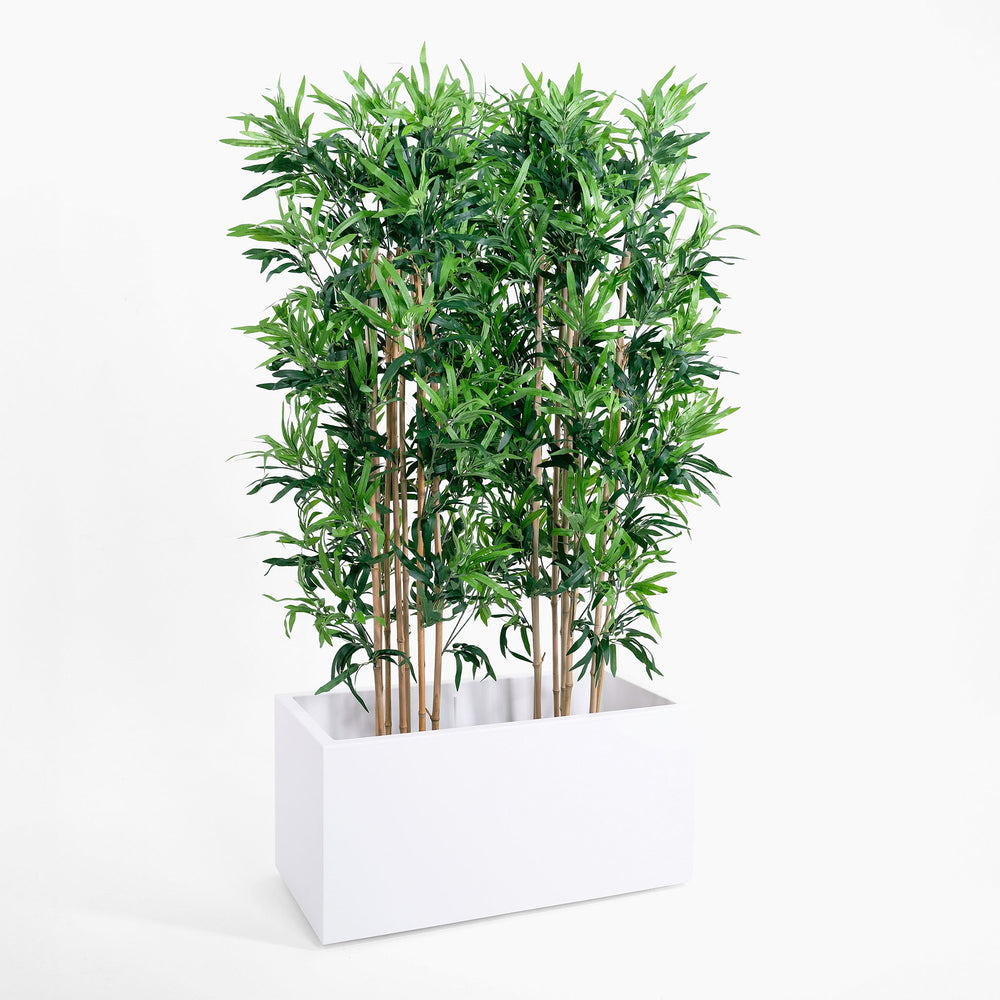 Artificial bamboo plant in a white rectangular planter on a white background