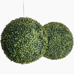 Two artificial green spherical plants on a white background