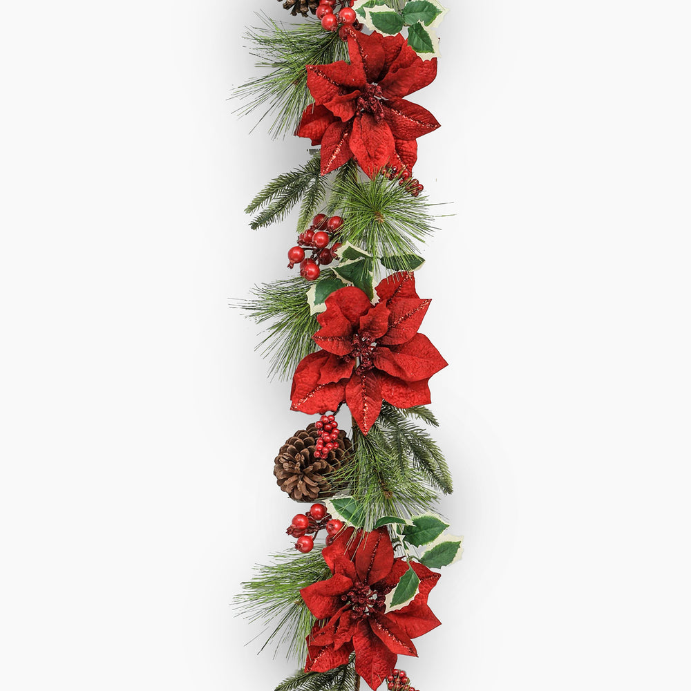 Decorative Christmas garland with red poinsettias, greenery, and pinecones on a white background