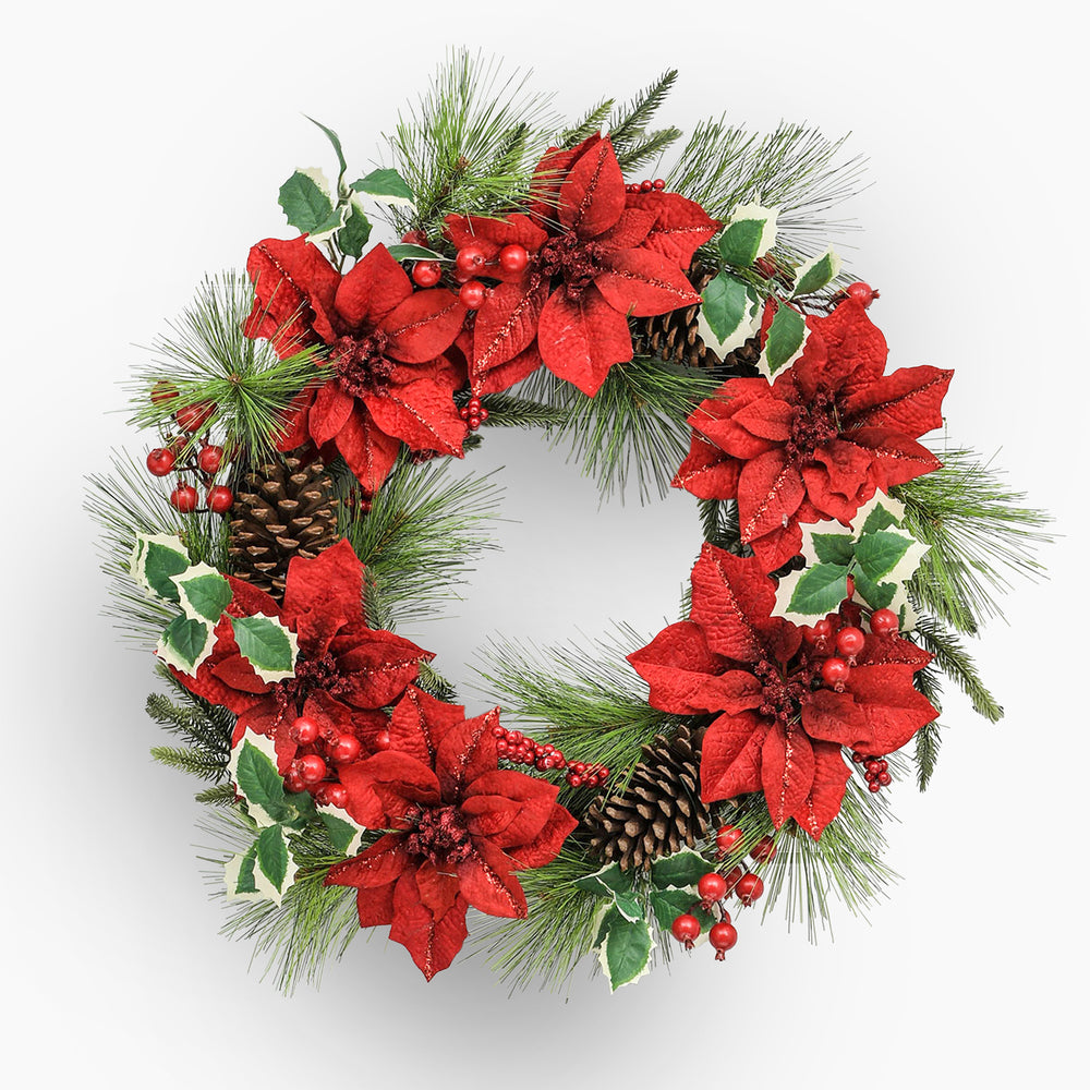 Christmas wreath with red flowers, greenery, and pinecones on a white background