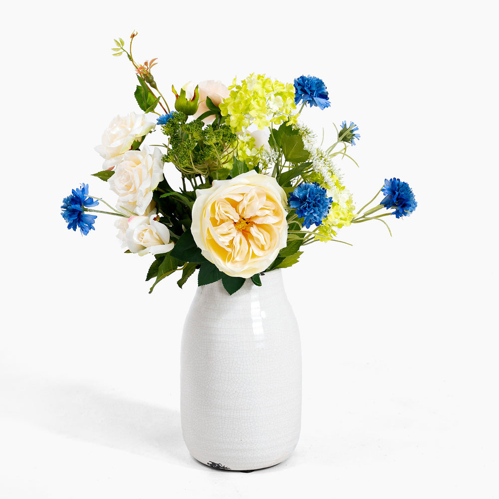 Floral arrangement in a white vase on a white background