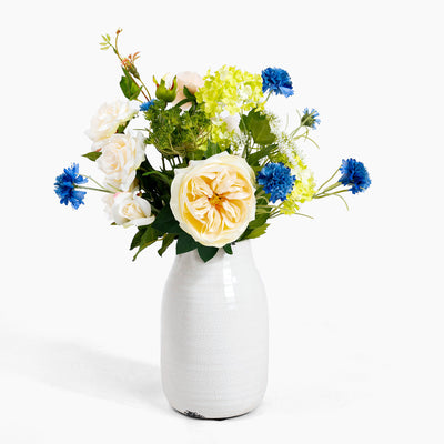 Floral arrangement in a white vase on a white background