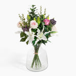 Bouquet of flowers in a clear glass vase on a white background