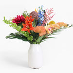 Colorful bouquet of flowers in a white vase on a white background