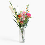 Bouquet of colorful flowers in a clear glass vase on a white background