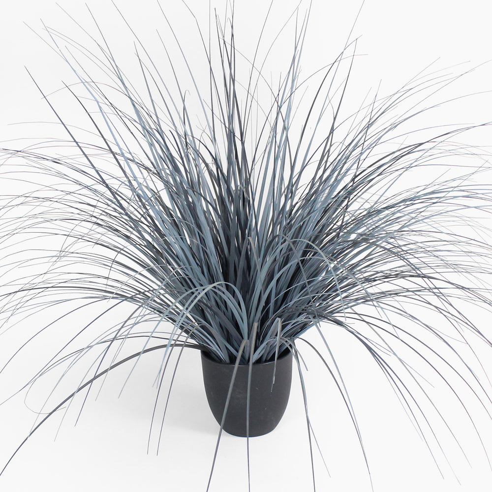 Faux potted plant with long, thin leaves on a white background