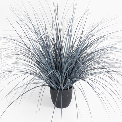 Faux potted plant with long, thin leaves on a white background