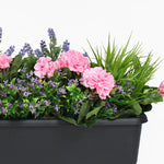 Floral arrangement with pink flowers and greenery in a black pot on a white background