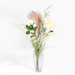 Bouquet of flowers in a clear vase on a white background