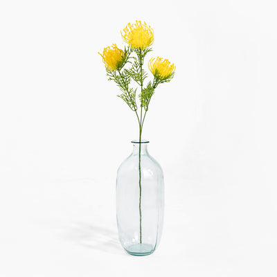 Clear glass vase with yellow flowers on a white background