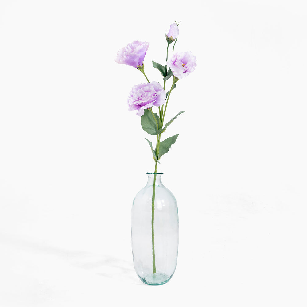 Clear glass bottle with purple flowers on a white background