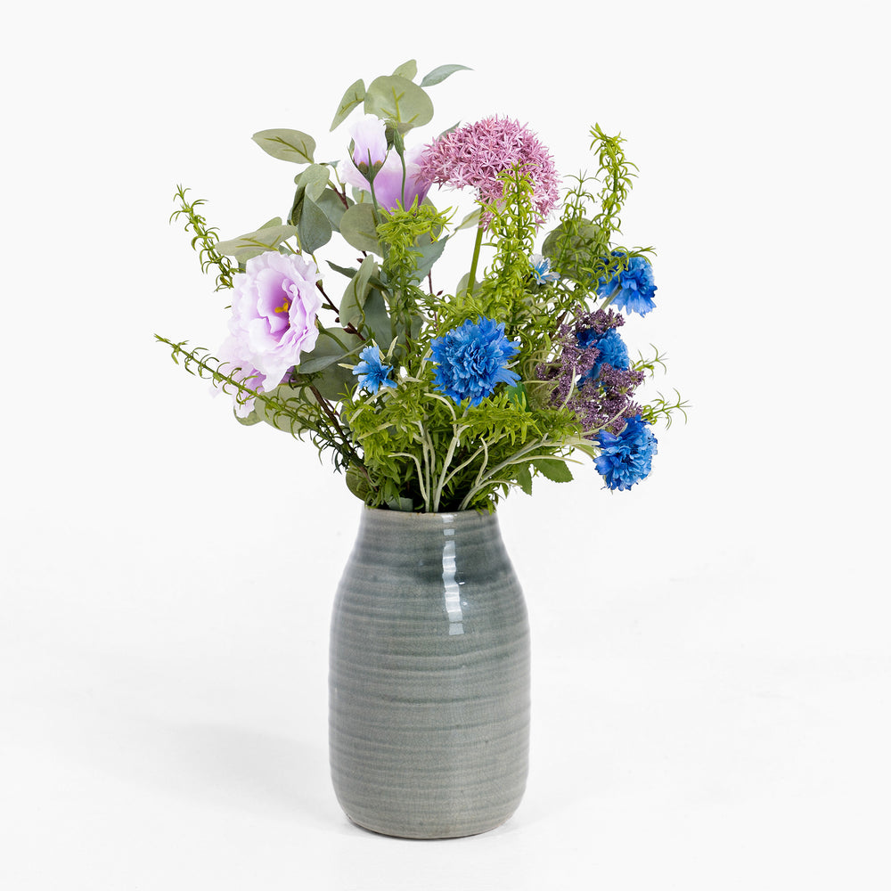 Gray ceramic vase with a bouquet of colorful flowers on a white background