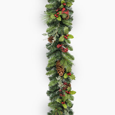 Christmas garland with greenery, berries, and pinecones on a white background