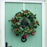 Artificial winter berry wreath on green front door