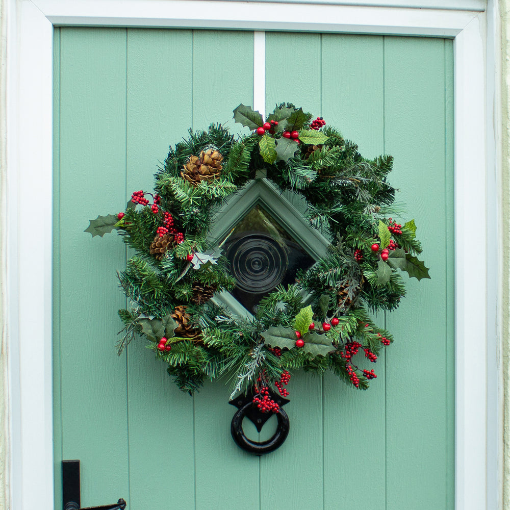 Artificial winter berry wreath on green front door