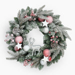 Decorative Christmas wreath with pink and silver ornaments on a white background