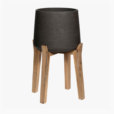 Black planter with wooden legs on a white background