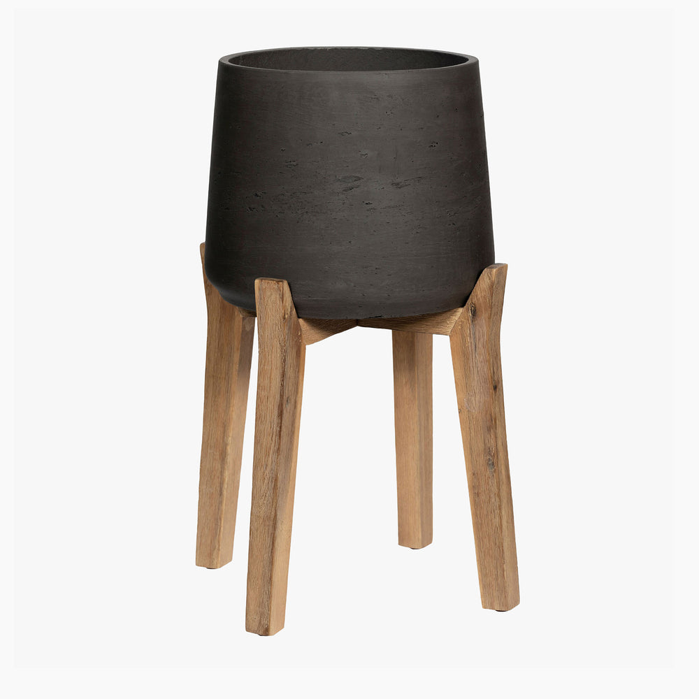 Black planter with wooden legs on a white background
