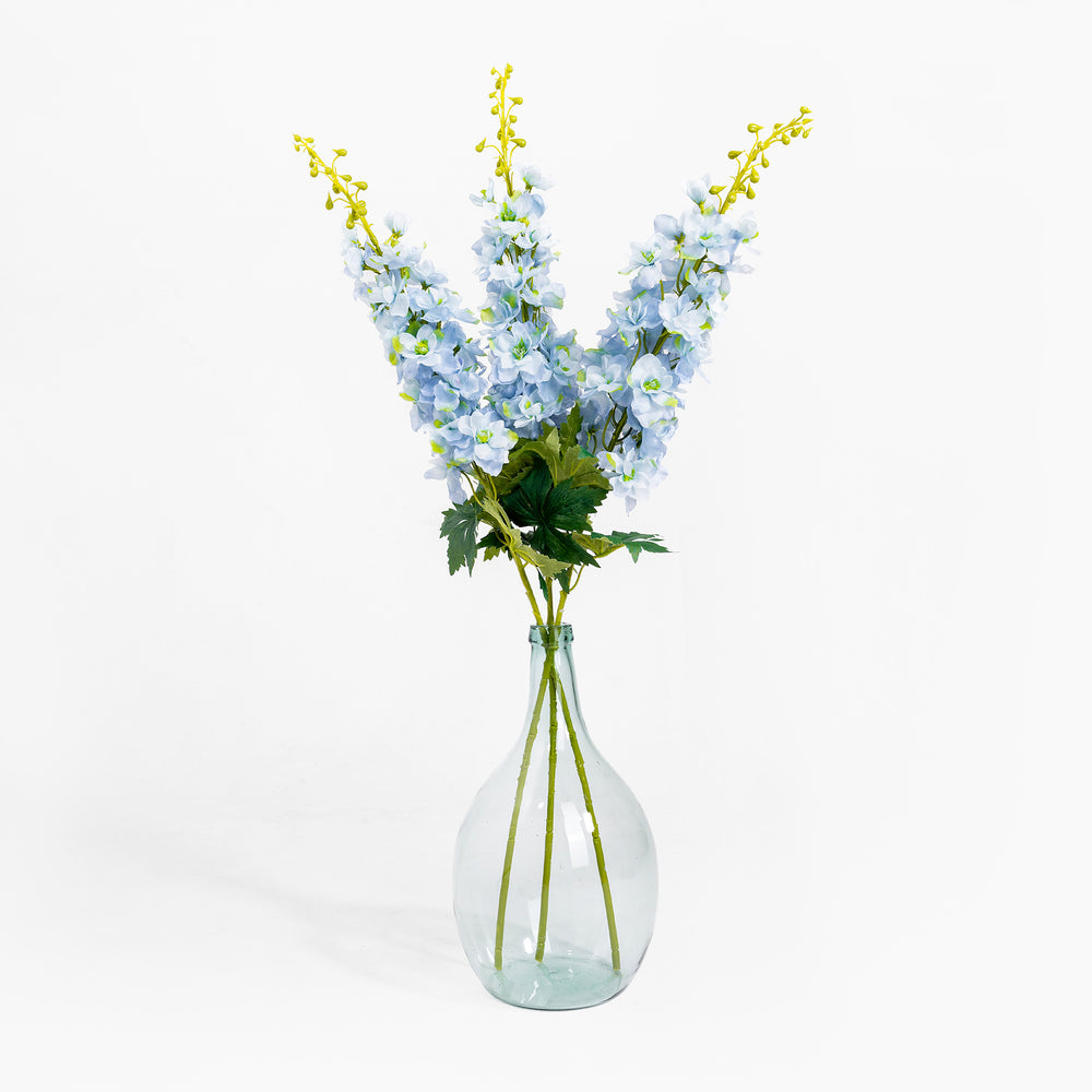 Clear glass vase with blue flowers on a white background