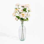 Clear glass vase with white flowers on a white background