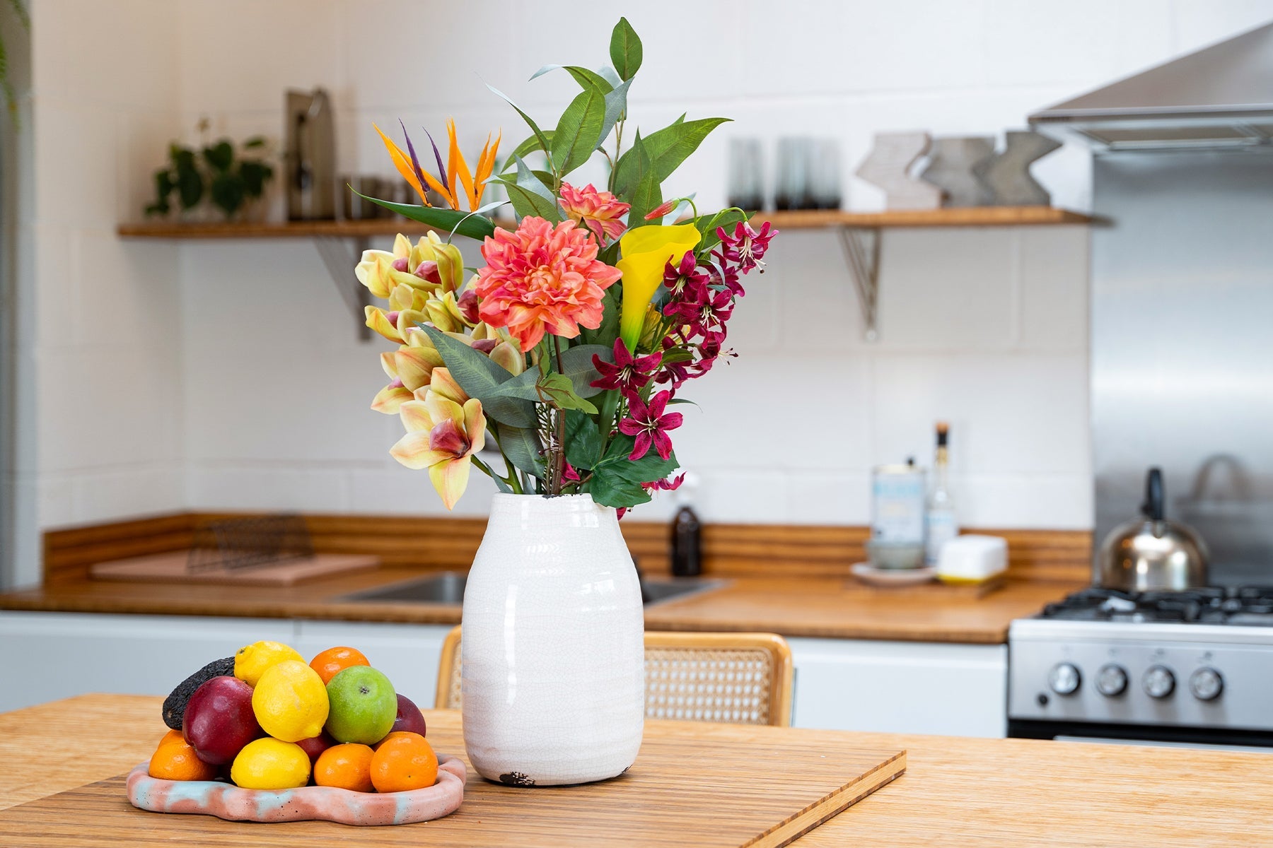 Artificial Hawaiian bunch in white vase in wooden kitchen