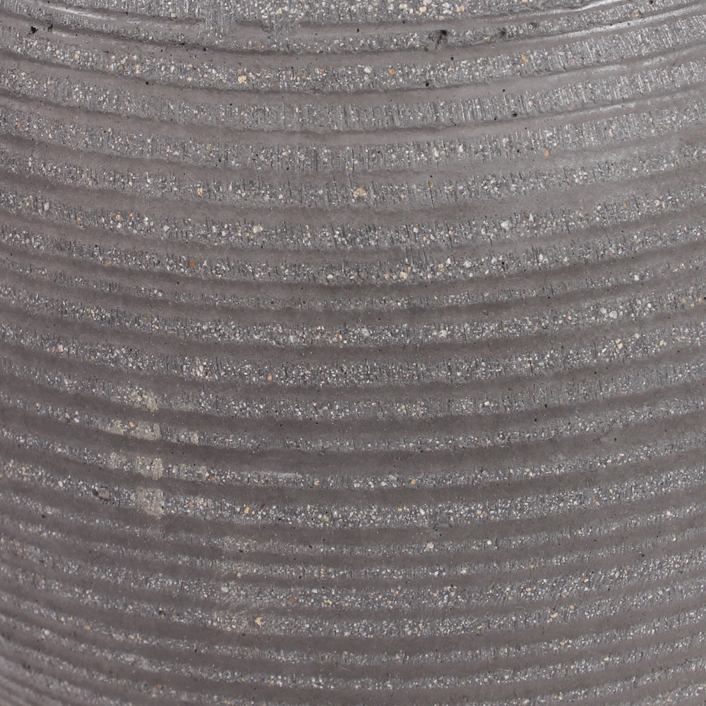 Close-up of a ribbed gray textured ficonstone surface with horizontal grooves and fine speckled material.
