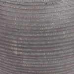 Close-up of a ribbed gray textured ficonstone surface with horizontal grooves and fine speckled material.