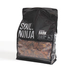A 5-liter black bag of Soil Ninja Bark mulch, featuring a clear window that displays the brown bark chips inside, set against a plain white background.