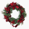 A festive Christmas wreath decorated with green pine branches, red glitter poinsettias, red velvet ribbons, red berries, and dark red ornaments, shown against a plain white background.