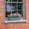 Window box with pink flowers on a brick wall