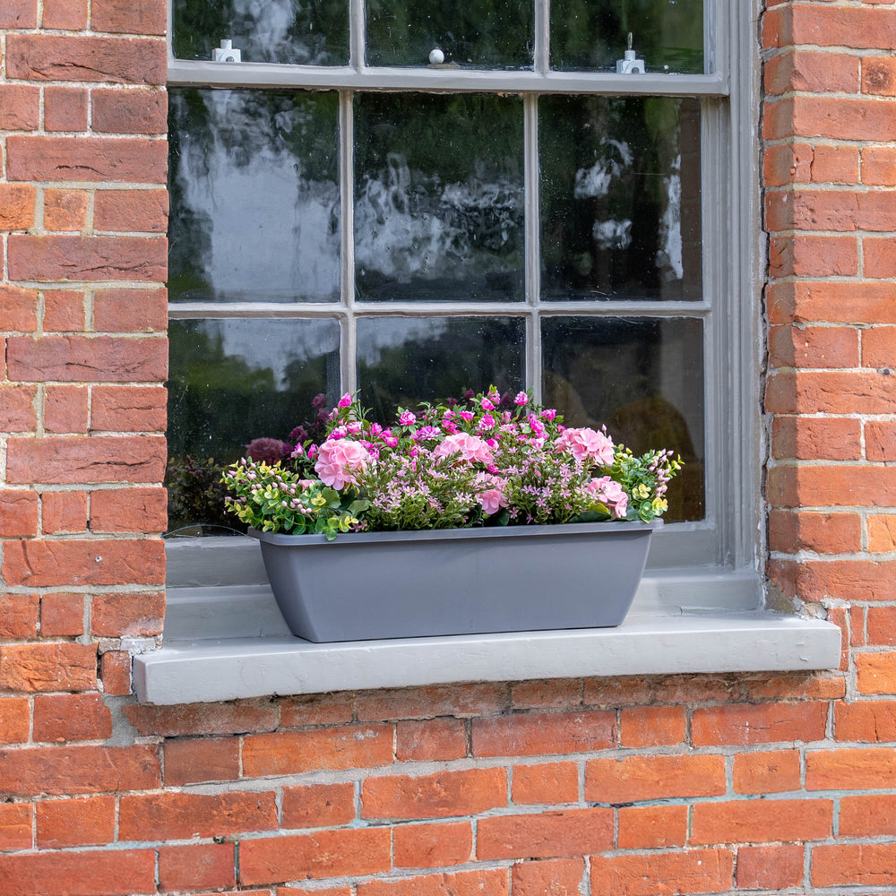 Window box with pink flowers on a brick wall