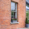 Brick building exterior with window box plants and wooden deck