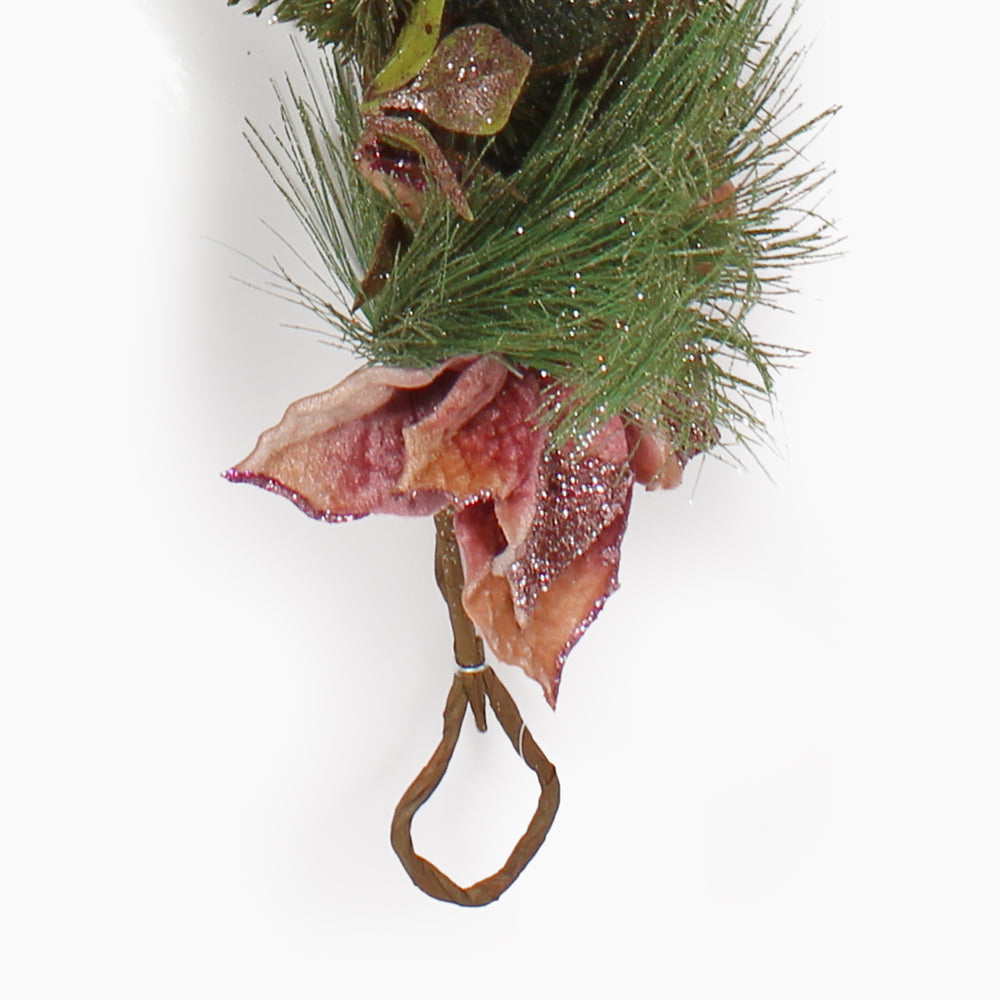 A close up of the hook at the end of a glittery pine garland with blush pink poinsettias on a white background.
