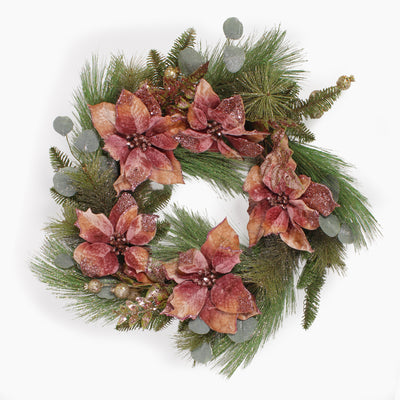 A festive holiday wreath featuring large, textured poinsettia flowers in dusty rose tones, mixed with green pine branches, eucalypts and small gold decorations on a white background.