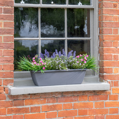 Window box with colourful flowers on a brick wall