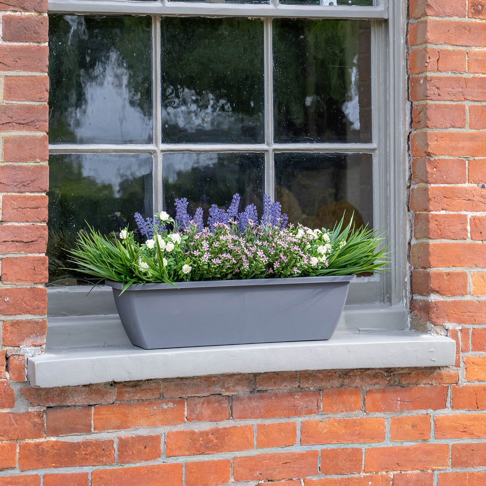 Window box with flowers on a brick wall