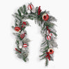 A festive Christmas wreath decorated with frosted green pine branches, red berries, red-and-white striped ornaments, white baubles, and donut ornaments, shown on a plain white background.