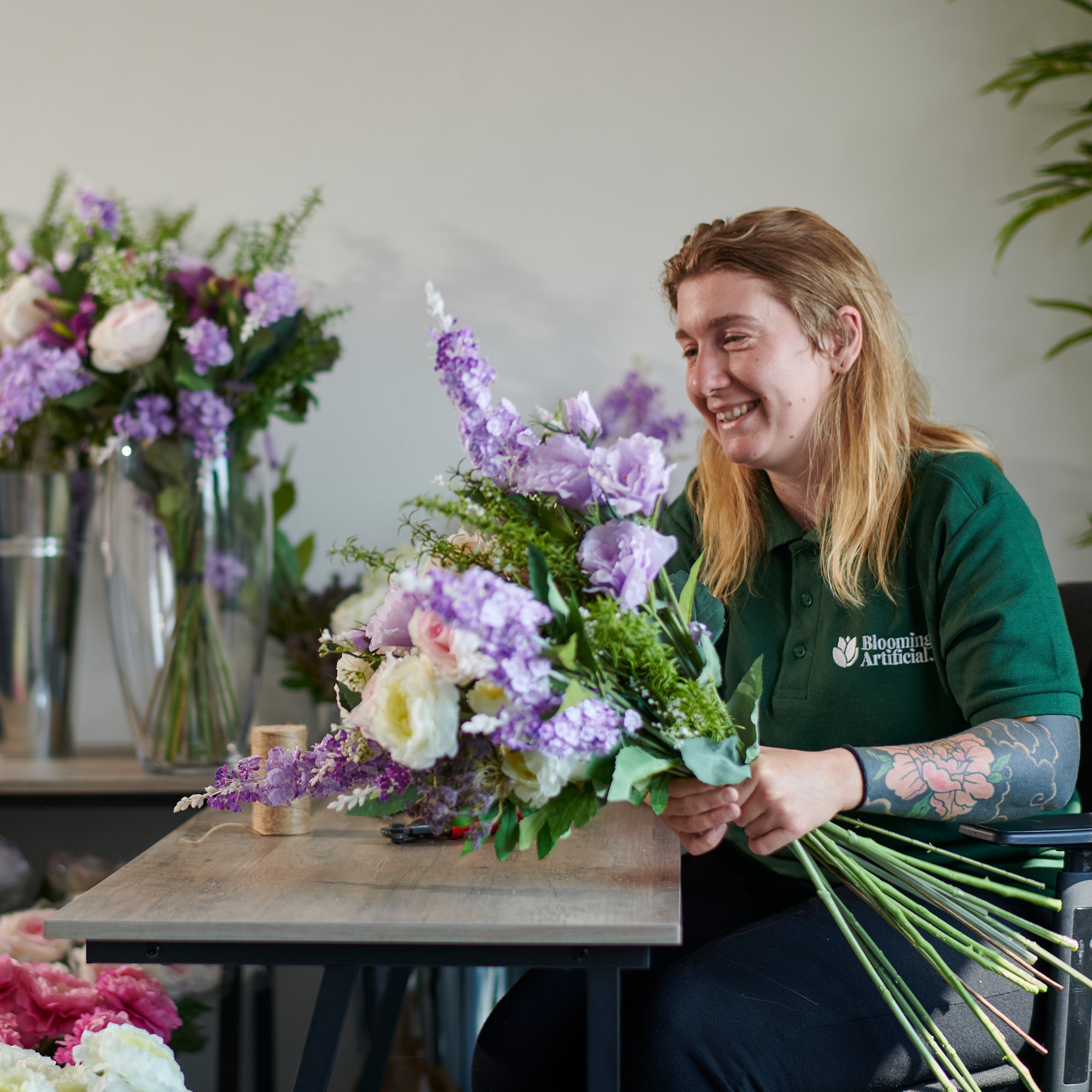 Woman holding a bouquet of flowers in a floral shop setting