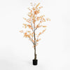 Artificial tree with orange leaves in a pot on a white background